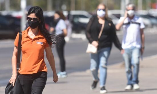 Pessoas usam máscara na pandemia, que fez o PIB do DF despencar