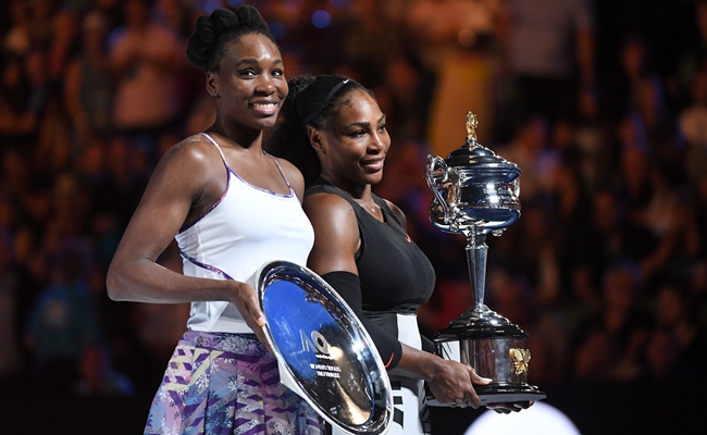 Serena Williams of the US (R) celebrates with the championship trophy during the awards ceremony after her victory against Venus Williams of the US in the women's singles final on day 13 of the Australian Open tennis tournament in Melbourne on January 28, 2017. IMAGE RESTRICTED TO EDITORIAL USE - STRICTLY NO COMMERCIAL USE / AFP / WILLIAM WEST / IMAGE RESTRICTED TO EDITORIAL USE - STRICTLY NO COMMERCIAL USE