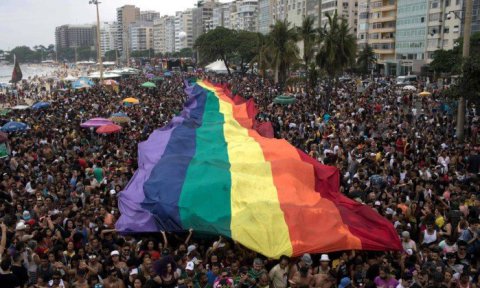 People-hold-a-huge-rainbow-flag-during-the-Gay-Pride-Parade-at-Copacabana-beach-in-Rio.jpg.pagespeed.ic_.X5L3-k-SDy
