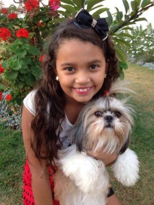 foto mostra garotinha com seu cãozinho.Adotar um pet